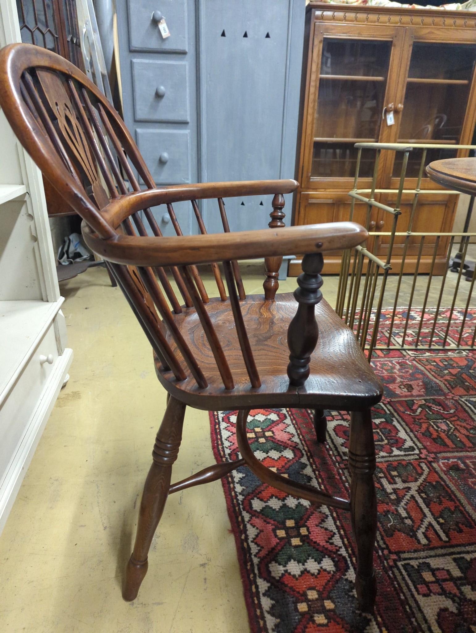 A near pair of mid 19th century Nottingham Area yew and elm Windsor elbow chairs with crinoline stretchers